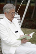 Foto: Senior man reading book on the swing Senior man reading book on the swing