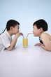 Foto: Boys sharing a glass of orange juice Boys sharing a glass of orange juice