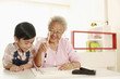 Foto: Boy observing senior woman writing calligraphy Boy observing senior woman writing calligraphy