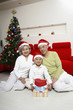 Foto: Boy posing with senior couple under Christmas tree Boy posing with senior couple under Christmas tree