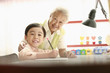 Photo: Senior woman assisting boy with his homework Senior woman assisting boy with his homework