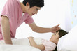 Man tucking girl to sleep