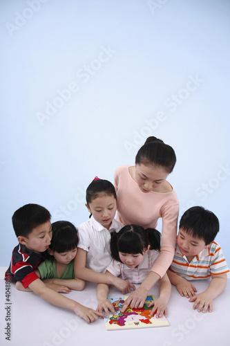 Photo: Woman teaching children with a map Woman teaching children with a map