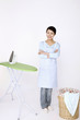 Woman wearing apron with arms crossed smiling