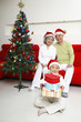 Foto: Boy holding a stack of presents, senior man and senior woman smiling in the background Boy holding a stack of presents, senior man and senior woman smiling in the background