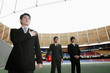 Businessman with hand on his chest and two other businessmen standing in the background