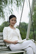 Foto: Woman listening to music on headphones while reading book Woman listening to music on headphones while reading book
