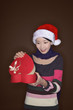 Foto: Woman with christmas hat opening present Woman with christmas hat opening present