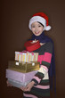 Foto: Woman with christmas hat holding a stack of presents Woman with christmas hat holding a stack of presents