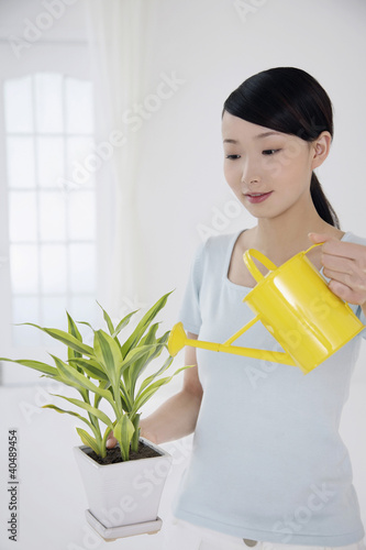 Foto: Woman watering potted plant Woman watering potted plant