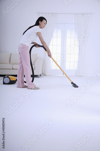 Foto: Woman vacuuming the floor Woman vacuuming the floor