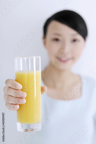 Foto: Woman holding a glass of orange juice, smiling Woman holding a glass of orange juice, smiling