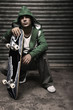 Man with green hooded sweater holding skateboard