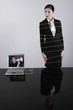 Businesswoman tied up with rope connected to laptop