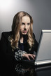 Businesswoman with chained hands using laptop