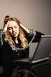 Businesswoman with chained hands using laptop