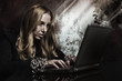 Businesswoman with chained hands using laptop