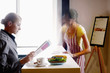 Businesswoman reading newspaper, waitress wiping the table