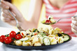 Photo: Woman enjoying a plate of fruit and vegetable pasta salad served with feta cheese and olives on the side Woman enjoying a plate of fruit and vegetable pasta salad served with feta cheese and olives on the side