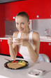 Photo: Woman holding a cup of coffee, rye crackers served with scrambled eggs, tomatoes, olives and fresh garden herbs in front of her Woman holding a cup of coffee, rye crackers served with scrambled eggs, tomatoes, olives and fresh garden herbs in front of her