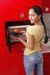 Woman taking out pecan muffin from the microwave