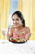 Photo: Woman enjoying a plate of fruit and vegetable pasta salad served with feta cheese and olives on the side Woman enjoying a plate of fruit and vegetable pasta salad served with feta cheese and olives on the side