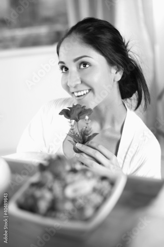 Photo: Woman daydreaming while holding flower Woman daydreaming while holding flower