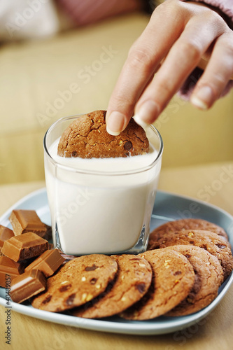 Photo: Woman dipping cookie into a glass of milk Woman dipping cookie into a glass of milk