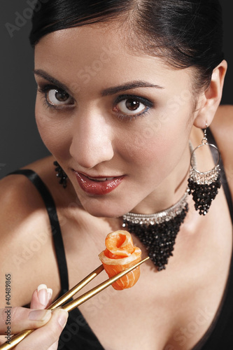 Foto: Woman eating salmon sashimi Woman eating salmon sashimi