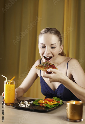 Photo: Woman enjoying her pizza and salad platter Woman enjoying her pizza and salad platter