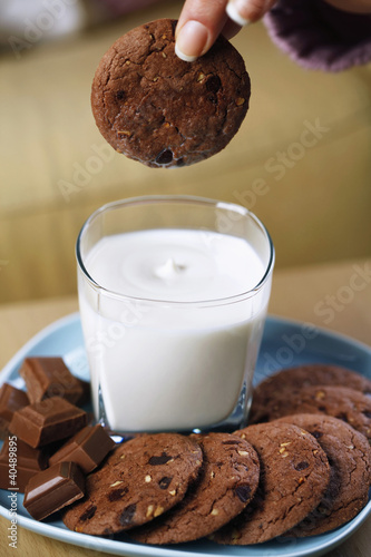 Photo: Woman dipping cookie into a glass of milk Woman dipping cookie into a glass of milk