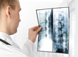 Rear view of young male doctor examining a xray Rear view of young male doctor examining a xray