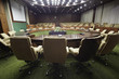 Round oak table with microphones and armchairs around it Round oak table with microphones and armchairs around it