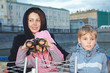 smiling woman with children stand on the background of city