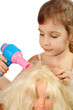 Happy girl dries doll hair by bright toy hair dryer isolated Happy girl dries doll hair by bright toy hair dryer isolated