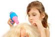 Little girl dries doll hair by bright toy hair dryer isolated Little girl dries doll hair by bright toy hair dryer isolated