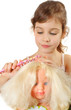 Girl combs doll hair by toy hairbrush isolated on white Girl combs doll hair by toy hairbrush isolated on white