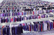 Big clothing store, rows with hangers with pants and t-shirt