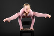 Foto: Girl gymnast wearing in pink suit took graceful pose at chair Girl gymnast wearing in pink suit took graceful pose at chair