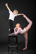 Foto: Girl and little boy gymnast took graceful pose at bark chair Girl and little boy gymnast took graceful pose at bark chair