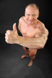 Undressed tanned bodybuilder smiles and thumbs up