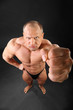 Undressed formidable tanned bodybuilder punches to camera