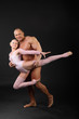 Undressed sunburnt bodybuilder holds graceful girl in studio