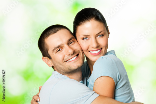 Photo: Portrait of young smiling couple, outdoors Portrait of young smiling couple, outdoors