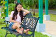 asian woman sitting and smile on bench