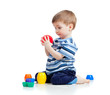 Funny little child is playing with cup toys while sitting on flo