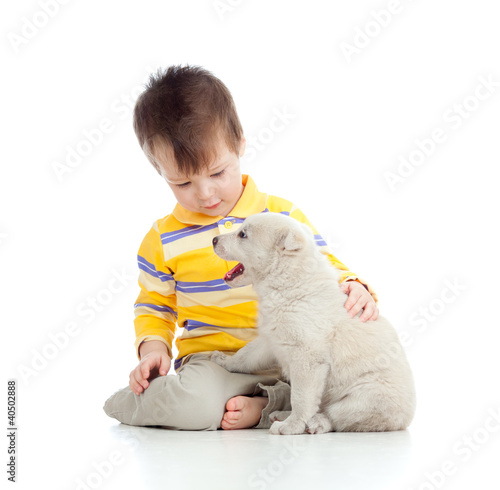 Foto: cute child playing with a puppy cute child playing with a puppy