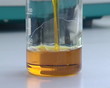 hand pour rape seed oil biodiesel stream flow bottle glass flask