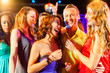 Party people dancing in disco or club