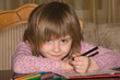 Little girl drawing with pencils at home